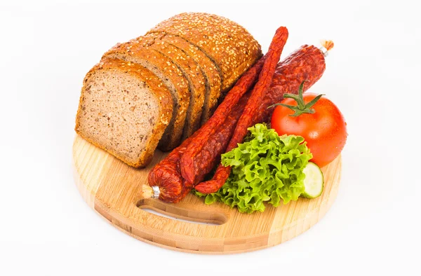 Pane e salsicce affumicate su piastra di legno — Foto Stock