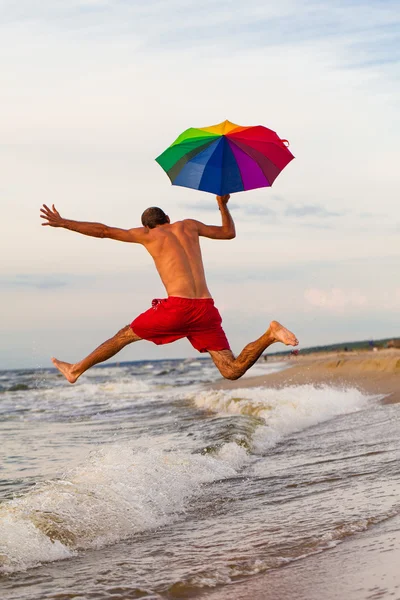 Happy man jumping on the beach — Stock Photo, Image