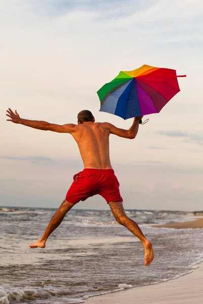 Happy man jumping on the beach — Stock Photo, Image