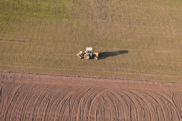 Вид с воздуха на поля для сбора урожая с трактором — стоковое фото