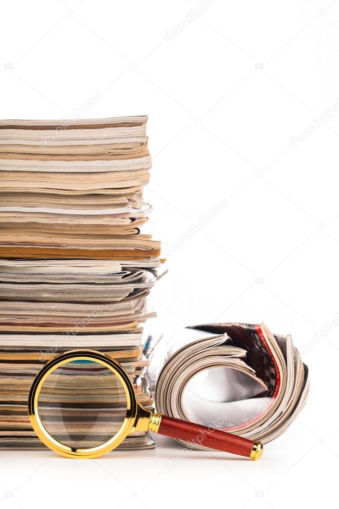 pile of newspapers and magnifying glass