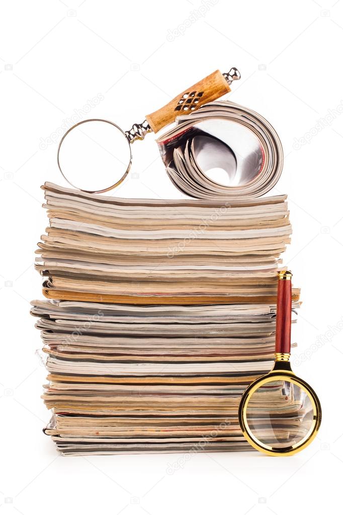 pile of newspapers and magnifying glass