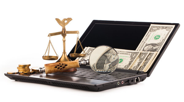 laptop computer keyboard money and magnifying glass