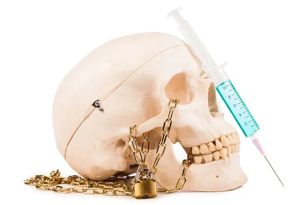 Şırınga ve insan kafatası üzerinde beyaz izole — Stok fotoğraf