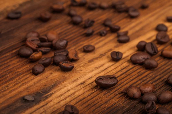 Coffee beans on old table — Stock Photo, Image