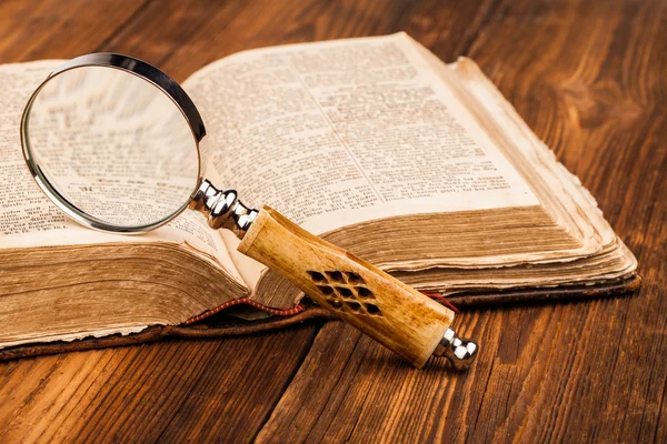 Magnifying glass and old book — Stock Photo, Image