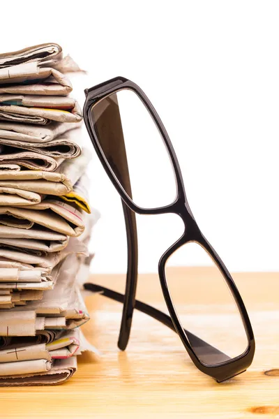 Högen med tidningar och läsglasögon — Stockfoto
