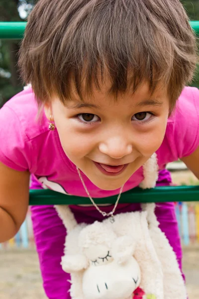 Glad, liten flicka som leker på lekplatsen — Stockfoto