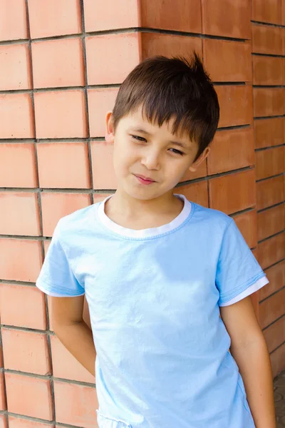 Sad boy against a brick wall Stock Image