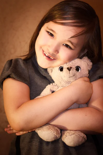 Niña con cuidado sosteniendo un oso de peluche —  Fotos de Stock