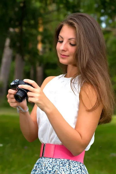 Beautiful smiling girl with camera on nature — Stock Photo, Image