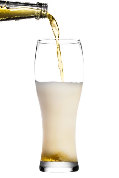 Bier ergießt sich in Glas auf weißem Hintergrund — Stockfoto