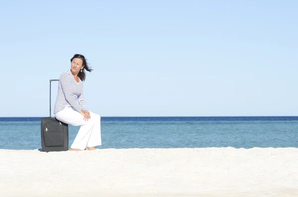 Donna single in attesa con bagagli in riva al mare — Foto Stock