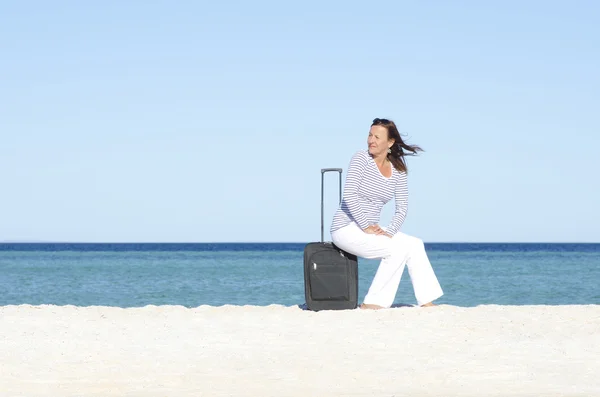Één vrouw te wachten met bagage aan zee — Stockfoto