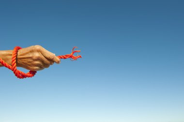 Kalçası ip gökyüzü arka plan üzerinde elini kavradı