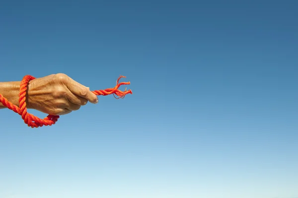 Hand griff auf zerrissenem Seil Himmel Hintergrund — Stockfoto