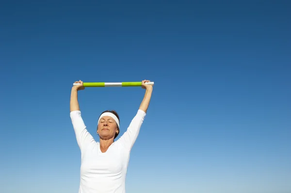 Active senior woman sky background — Stock Photo, Image