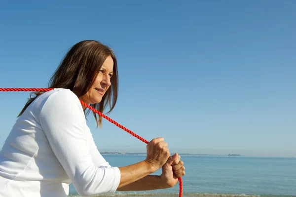 Frau zieht Seil Ozean Hintergrund — Stockfoto
