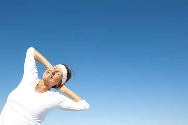 Sporty senior woman sky background — Stock Photo, Image