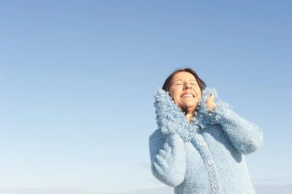 Smiling woman winter sky isolated — Stock Photo, Image