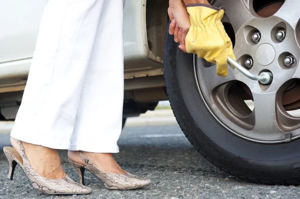 Mulher trocando pneu do carro — Fotografia de Stock