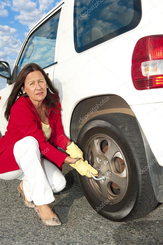 Woman changing car tyre