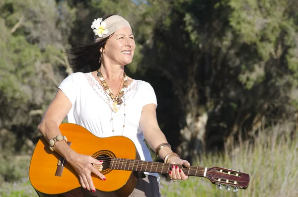 Gelukkig volwassen hippie vrouw met gitaar — Stockfoto