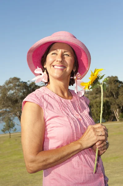 Glückliche Dame mit Sonnenblume im Park — Stockfoto