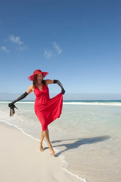 Sexy mature woman red dress beach — Stock Photo, Image