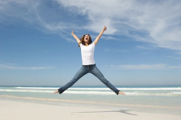 Alegre feliz jovem mulher pulando na praia — Fotografia de Stock