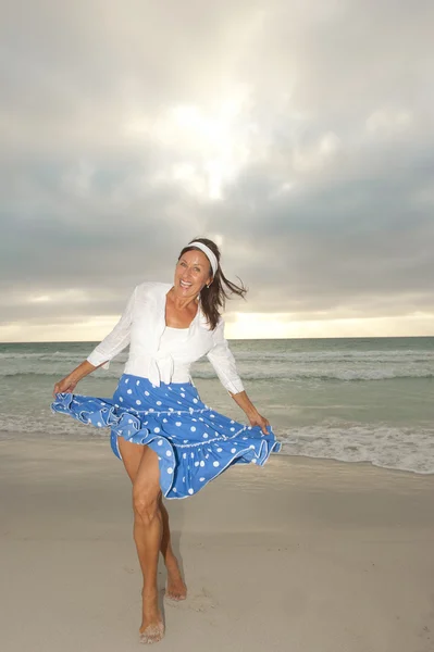 Happy attractive mature woman beach storm clouds — Stock Photo, Image