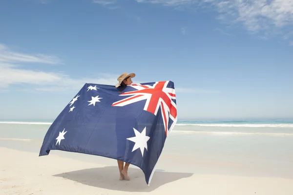 Attraktiv kvinna australiska flaggan på ocean beach — Stockfoto