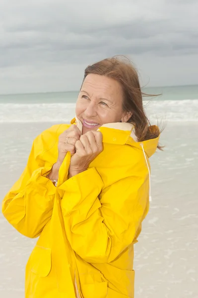 Mulher capa de chuva outono tempestade na praia — Fotografia de Stock