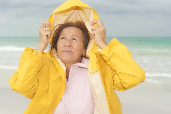 Kvinna regnrock höst väder på stranden — Stockfoto