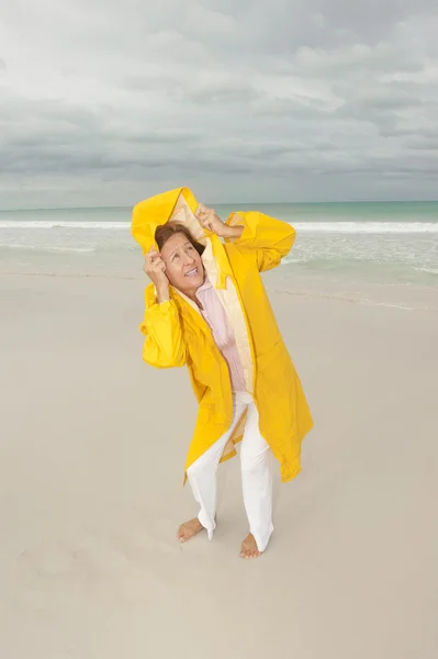 Mulher capa de chuva outono tempestade na praia — Fotografia de Stock