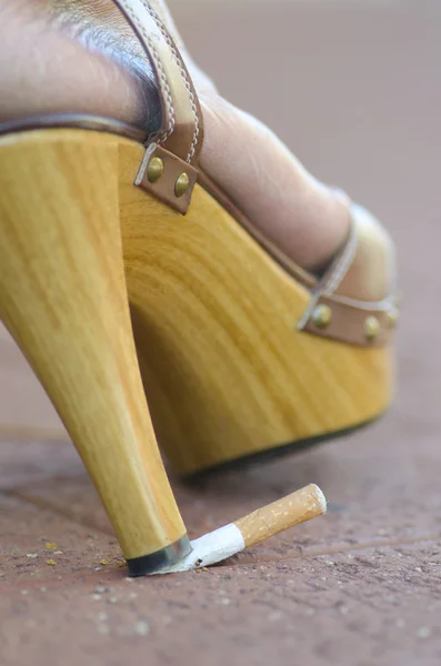 Cigarette abused by high heel shoe — Stock Photo, Image