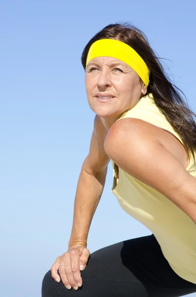 Attractive exercising senior woman sky isolated — Stock Photo, Image