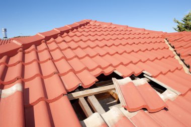 Damaged red tile roof construction house