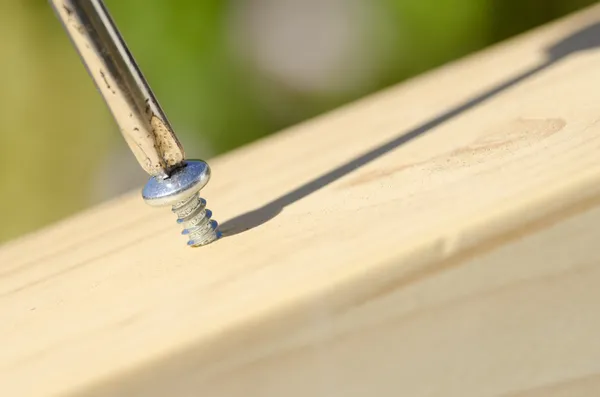 Tornillo y destornillador en superficie de madera —  Fotos de Stock