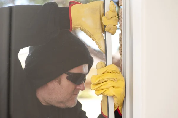 Einbrecher brechen Fenster eines Hauses auf — Stockfoto