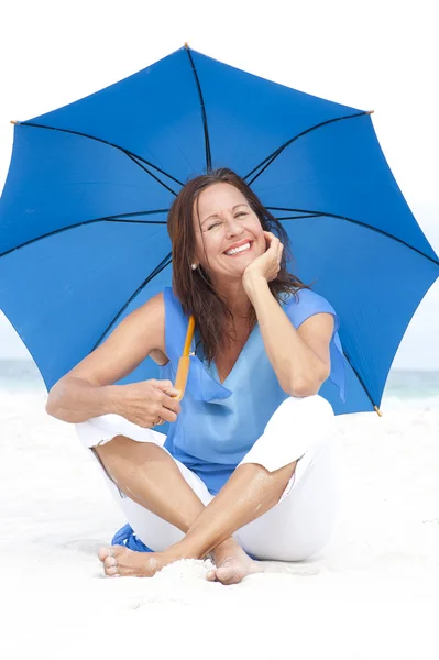 Szczęśliwa kobieta dojrzala niebieski parasol plaża — Zdjęcie stockowe