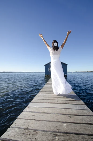 Joyful woman white dress on boardwalk at sea — Stock Photo, Image