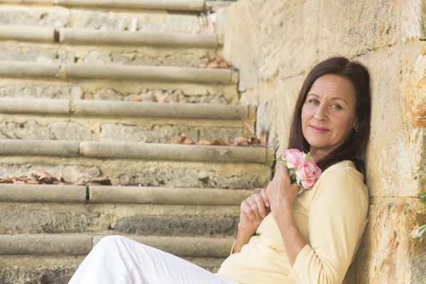 Atractiva mujer madura enamorada de rosa — Foto de Stock