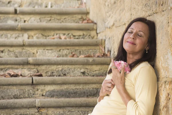 Happy mature woman in love with rose — Stock Photo, Image