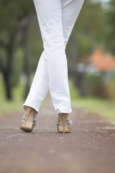 Vrouw hoge hakken gekruiste benen buiten — Stockfoto