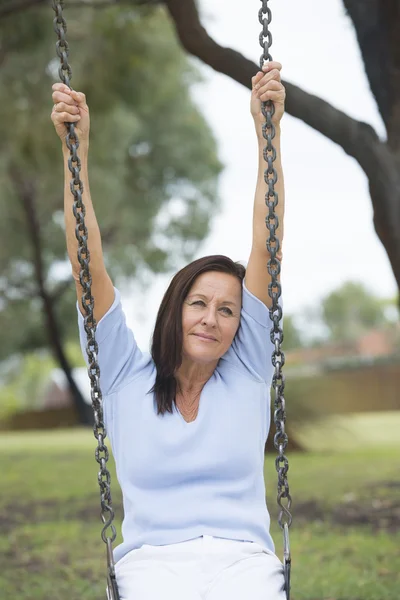 Happy Relaxed mature woman on swing outdoor — Stock Photo, Image