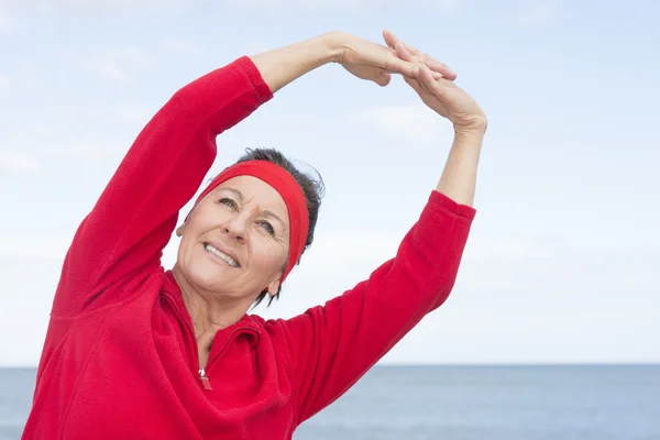 Volwassen vrouw uitrekkende oefening Oceaan — Stockfoto