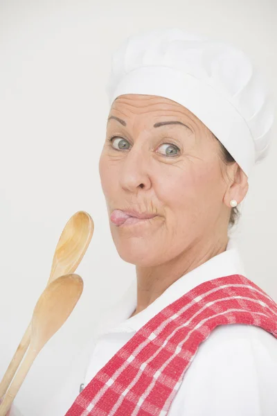 Portrét ženy šéfkuchař s ukazující jazyk — Stock fotografie
