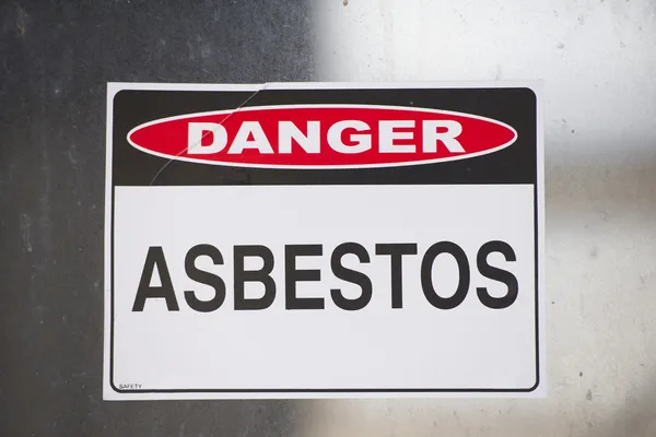 Asbestos danger sign warning on glass — Stock Photo, Image