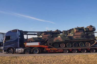  Uzun bir araç. Tank şasesine bir havan topu. Standart dışı, alışılmadık yol taşımacılığı. 